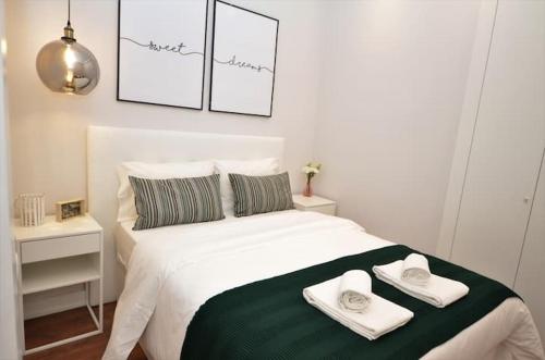 a bedroom with a white bed with towels on it at GuestReady - Lemon House with Private Garden in Lisbon