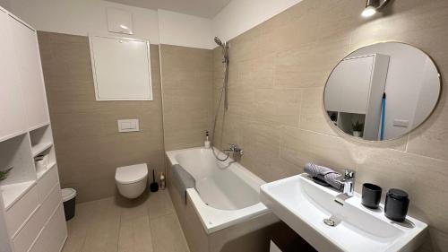 a bathroom with a sink and a tub and a mirror at Wiener Townhouse Staatsoper in Vienna