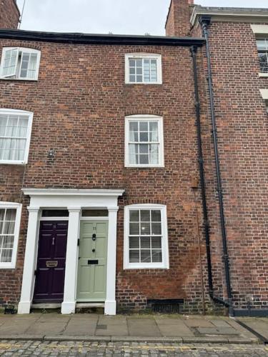 a brick building with two doors and two windows at Chester City Centre townhouse in Chester