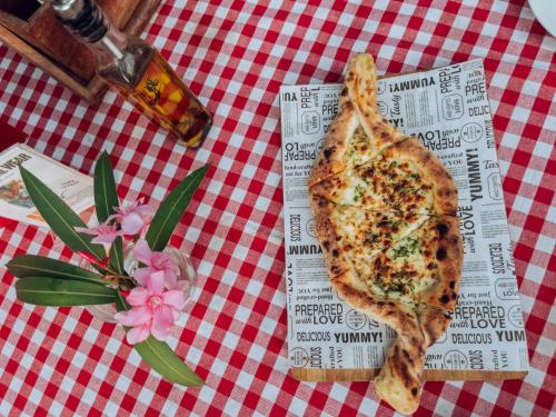 a slice of pizza sitting on a table with a flower at Casa Do Leão A 150 year Old Portuguese Home in Nerul