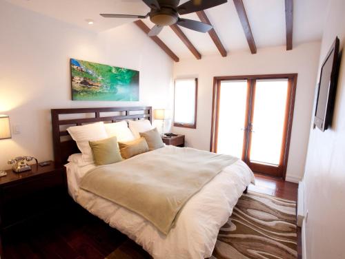 a bedroom with a large bed with a ceiling fan at Amazing Luxury ocean front Hamilton Cove Villa welectric cart in Avalon