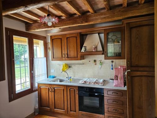 una cocina con armarios de madera y fregadero en Villa Galetta, en Imola