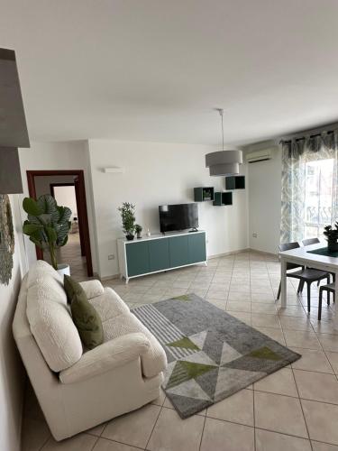 ein Wohnzimmer mit einem Sofa und einem Tisch in der Unterkunft Santu Marcu apartment in Decimomannu