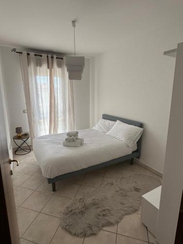 ein Schlafzimmer mit einem Bett in einem Zimmer mit einem Fenster in der Unterkunft Santu Marcu apartment in Decimomannu