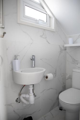 a white bathroom with a sink and a toilet at Taheli Riverside Townhouse in Tourist Area in Paphos