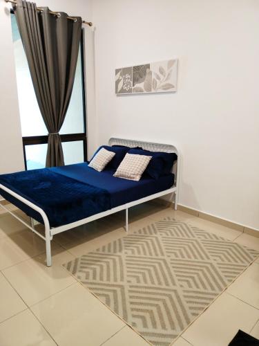 una camera da letto con un letto con lenzuola blu e una finestra di ART CASIA HOMESTAY BERTAM a Kepala Batas