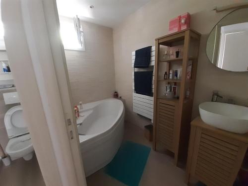 une salle de bain avec une baignoire blanche et un lavabo dans l'établissement Maison indépendante en pleine Nature, à Roquebrune-sur Argens