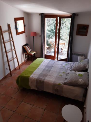 une chambre avec un lit et une grande fenêtre dans l'établissement Maison indépendante en pleine Nature, à Roquebrune-sur Argens