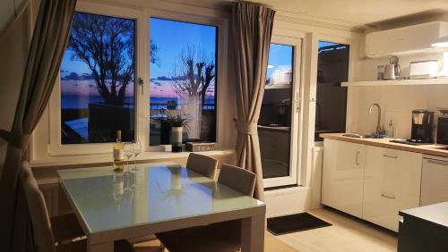 a kitchen with a table and some windows at Slapen aan het IJsselmeer - with SEAVIEW and SUNSET in Stavoren