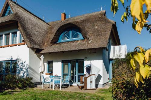 a house with a thatched roof with a patio at Bernstein in Born