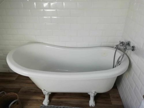 a white bath tub in a bathroom with a tile wall at Studio au coeur de la vallée de la Loire in Azay-sur-Cher