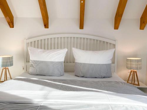 a bedroom with a white bed with two lamps at Beach Loft in Zingst