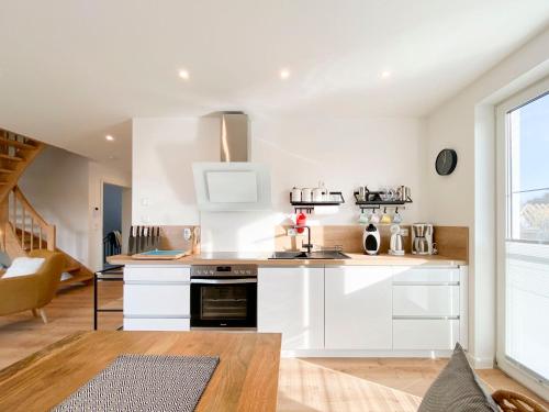 a kitchen with white cabinets and a stove at Beach Loft in Zingst