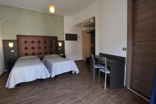 a bedroom with two beds and a table and chairs at Hotel Piola in Milan