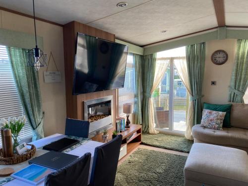 un soggiorno con TV a schermo piatto a parete di 2-Bed Lodge in Cockermouth a Cockermouth