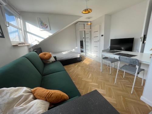 sala de estar con sofá verde y mesa en Kawalerka Premium A 29m2 - po remoncie - nowa! en Varsovia