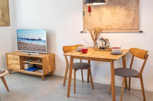 une salle à manger avec une table et une télévision dans l'établissement Cozy One, à Zingst