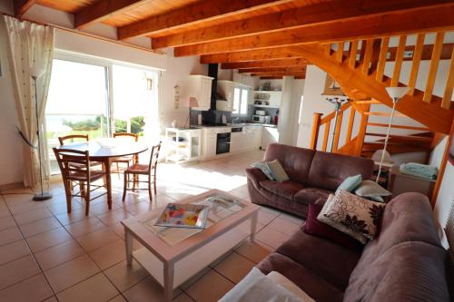 un salon avec un canapé et une table dans l'établissement 303 La Villa Courlis Les pieds dans l eau, à Plouhinec