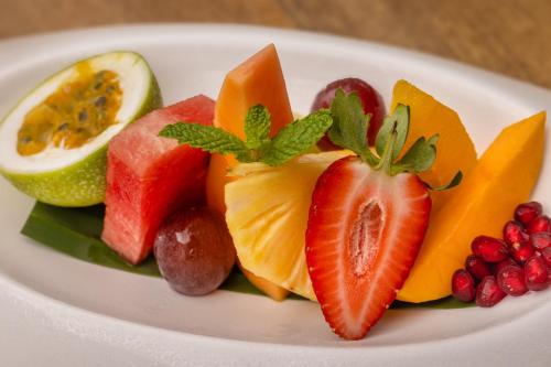 a white plate topped with fruit on a table at Bolagala Agro Floating Resort in Negombo