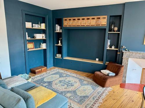 sala de estar con paredes azules y sofá en Le Canadair, Grand T2 lumineux, en Montauban