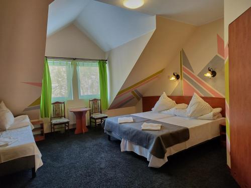 Cette chambre comprend un lit et deux chaises. dans l'établissement DW Mieszko, à Karpacz