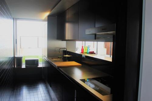 a kitchen with black cabinets and a counter top at Spacious Studio by the University in San Vicente del Raspeig