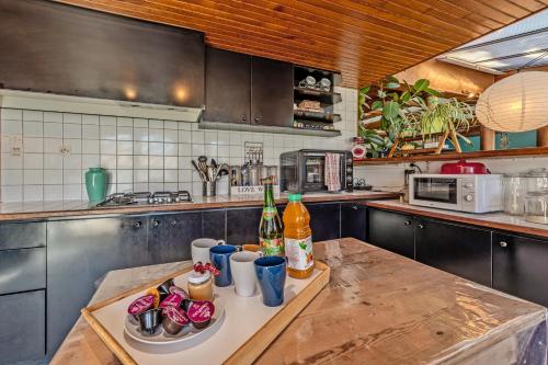 a kitchen with a table with drinks and bottles on it at Maison Aubépines -Jolie maison avec piscine privée in Brignogan-Plages