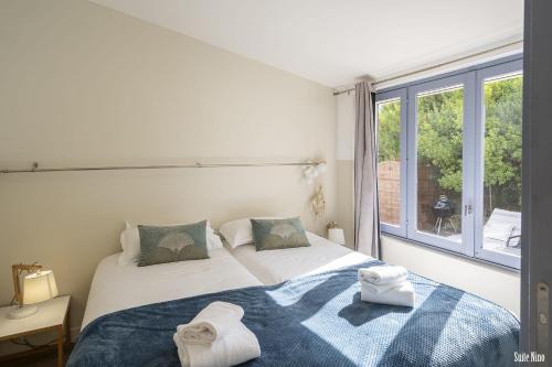 a bedroom with two beds and a large window at Résidence CasaBianca Porticcio - Nino in Grosseto-Prugna