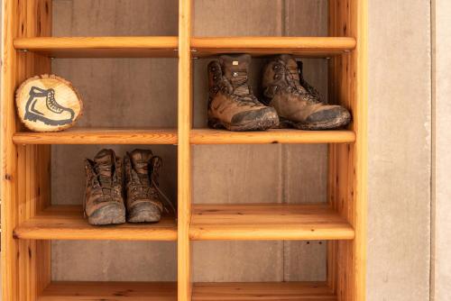 a wooden shelf with a bunch of shoes on it at Ferienwohnung Weitblick in Bruchweiler-Bärenbach