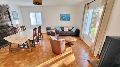un salon avec une table et un canapé dans l'établissement 719 - Villa Hortensias au calme entre terre et mer, à Plouhinec
