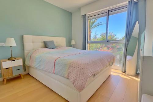une chambre avec un lit et une grande fenêtre dans l'établissement The Flower Garden, à Nice