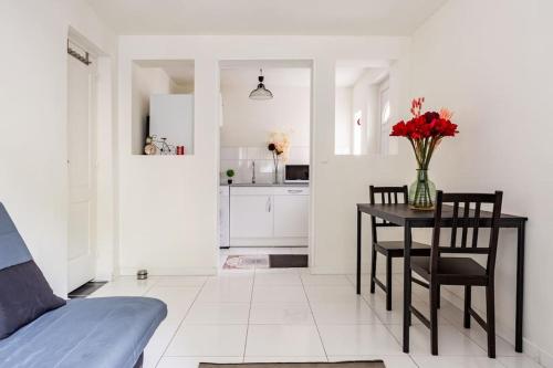 ein Wohnzimmer mit einem Tisch und einer Blumenvase in der Unterkunft studio lumineux in Choisy-le-Roi
