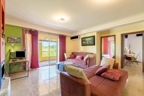 a living room with a couch and a tv at Casa D' Irene in Ágios Matthaíos