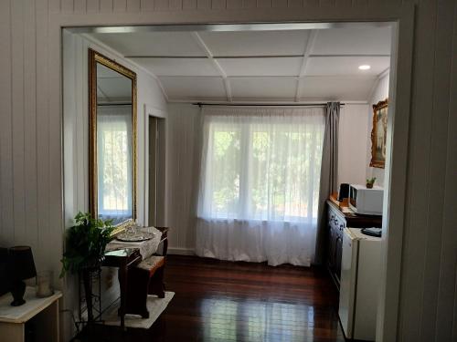 a living room with a large window and a kitchen at Memory Lane Accommodation in Mount Tamborine
