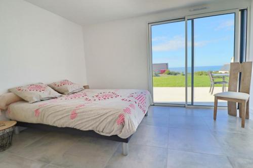 una camera da letto con un letto e vista sull'oceano di 695-Villa Kersiny proche plages a Plouhinec