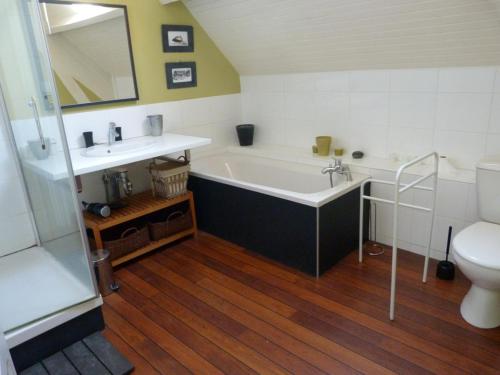 a bathroom with a tub and a sink and a toilet at 534-Villa de la plage-Plage a 100m in Audierne