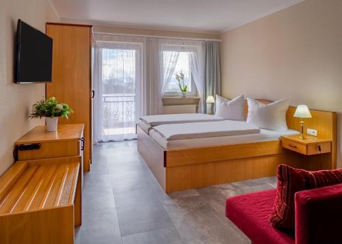 een hotelkamer met een bed en een bank bij Hotel Riesberghof in Lindberg