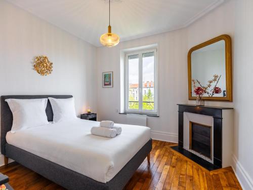 - une chambre avec un lit, une cheminée et un miroir dans l'établissement Le Coquet de Pasteur - À 5 minutes à pied de Nancy Thermal, à 10 min du campus ARTEM, à Nancy