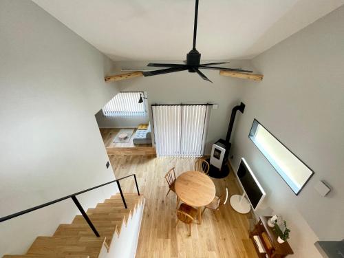 ein Wohnzimmer mit einem Deckenventilator und einem Tisch in der Unterkunft Spruce Cottage in Yuzawa