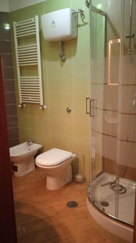 a bathroom with a toilet and a glass shower at B&B Serena in Casapulla