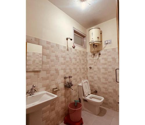 y baño con aseo y lavamanos. en Sunrise Guest House en Kasol