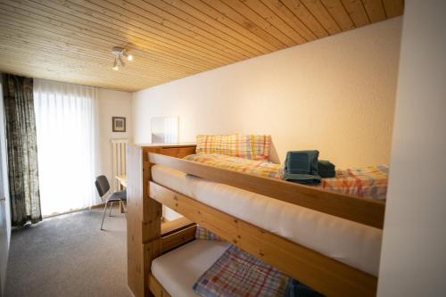 シュクオルにあるFeriensiedlung Trü 18のベッドルーム1室(二段ベッド1組、ノートパソコン付)