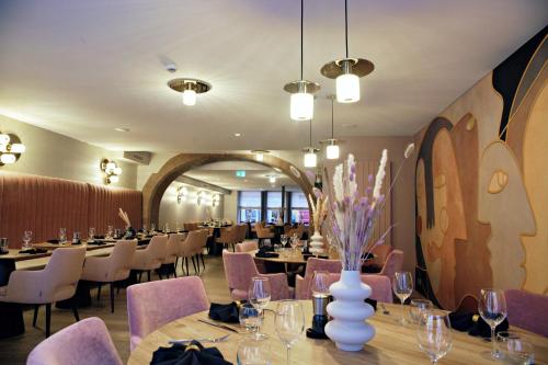 ein Restaurant mit Tischen und Stühlen in einem Zimmer in der Unterkunft Hotel-Restaurant St-Christophe in Belfort