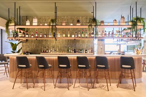 un bar con cuatro taburetes delante de un mostrador en Catalonia La Maquinista, en Barcelona