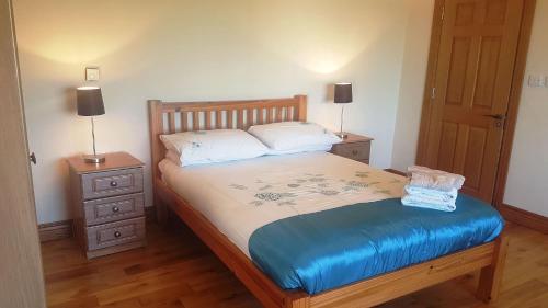 a bedroom with a bed with two night stands and two lamps at Coral Strand Lodge in Ballyconneely