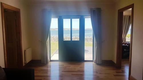 an open door with a view of the ocean at Coral Strand Lodge in Ballyconneely