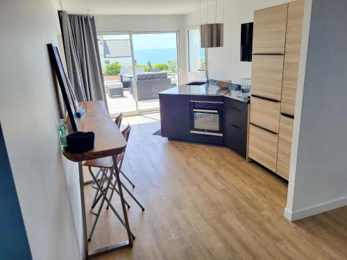 une cuisine avec une table et un tableau dans une pièce dans l'établissement 713-Villa du Roz-Grand confort, à Plouhinec