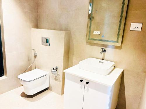 uma casa de banho com um WC, um lavatório e um espelho. em CozyLuxury apartment solaris em Acra