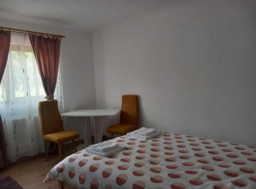 a bedroom with a bed and two chairs and a table at La Lacuri in Sovata