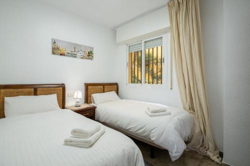 two twin beds in a room with a window at ESPECTACULAR PISO EN EL CORAZON DE MARBELLA in Marbella
